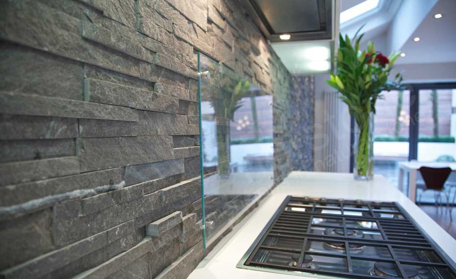 Natural Stacked Stone Backsplash made with Norstone series Charcoal Ledgestone panel system with frosted glass guard near stove tops