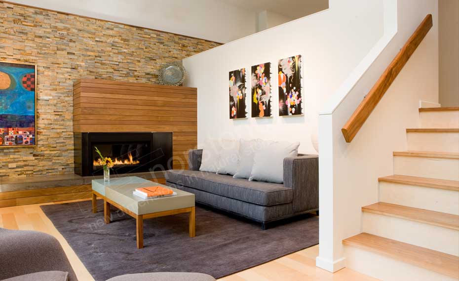Stacked Stone Fireplace in a living room with a dimensional stone panels used as the feature wall and wood paneling on the fireplace surround